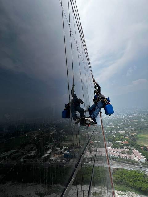 Técnicos de Brillomatic limpiando cristales en altura sobre una torre en Monterrey